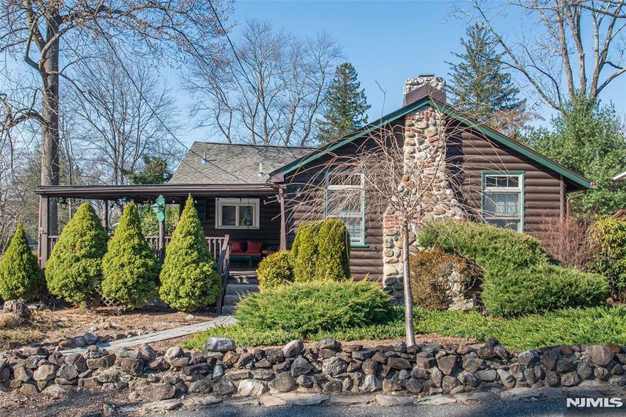 Call Reiley Phelan for all showings and info 201-951-4877. Packanack's Best Kept Secret! This fully renovated 2-bedroom, 1-bath cabin ranch blends rustic charm with modern upgrades. The vaulted, beamed ceiling living room features an original stone wood-burning fireplace, expansive windows, and French doors to a wrap-around covered porch. The kitchen boasts quartz countertops, stainless steel appliances, a farmhouse sink, and a microwave drawer, with a breakfast nook leading to the dining room. Hardwood floors throughout. The walk-out basement includes laundry and a cedar closet. The fully fenced backyard offers a paver patio, built-in fire pit, and gas hook-up for grilling. Zero-landscaping design features rock-filled walkways tree management and low maintenance care with incredible beauty. Additional perks: new roof, paved driveway with extra parking, and expansion-ready architectural drawings. Walking distance to NJ Transit bus stop. A rare gem offering tranquility and convenience!