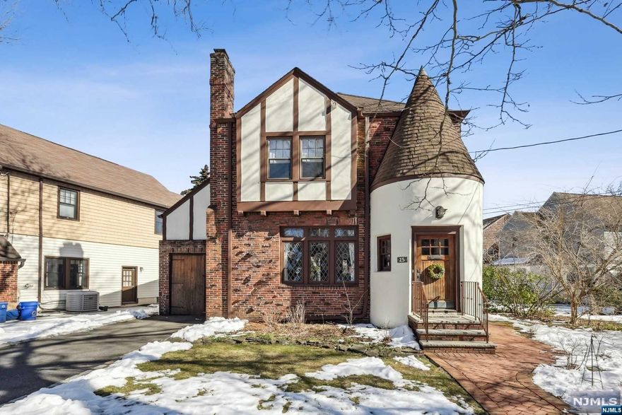 Storybook Tudor w/a white stucco turret at the entrance. The foyer greets you w/a staircase to a low landing for accesses to the kitchen. Natural light floods through leaded glass windows w/colored insets. LR includes a WBFP w/tiled surround, & high beamed ceiling. The arched doorway leads to expansive FDR that opens to the custom-designed kitchen. Quarter-sawn oak cabinetry is used throughout, many with glass fronts. Additional features: high-end SS appliances, including a 5-burner DCS range, limestone counters, a wine fridge & a tile backsplash. Double French doors in kitchen to the rear porch. The 2nd Fl. includes 3 BDRMs (one used as a den w/custom-built shelving) & spacious, updated main bath w/heated floor & walk-in shower. Finished basement has a decorative stone FP, recessed lighting, newer laundry room & bonus room ideal for an office. Level fenced backyard w/patio. CAC is 3 years old. Gleaming hardwood floors & thermal windows throughout.