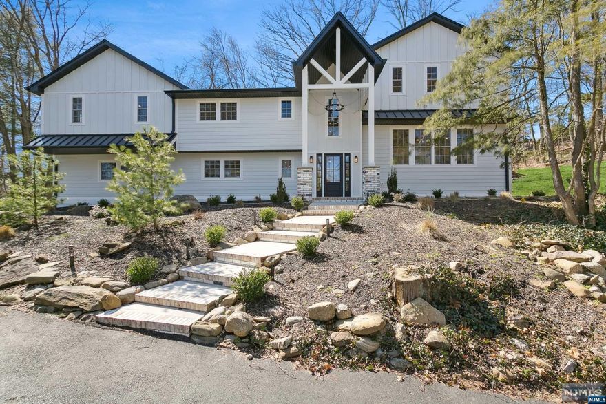 Welcome to your private sanctuary atop the hills of Woodcliff Lake in this opulent and new construction (over existing foundation) home. Step into the grand entry foyer flowing into the formal living room showcasing designer fireplace, or access the patio overlooking your verdant, breathtaking backyard. The living room is complimented by a modern powder room & direct access to your 2-car garage. Exquisite hickory hardwood floors lead the way throughout the home, guiding you upstairs to the light-filled open-concept 1st floor. Here, you'll discover a large family room, dining room, & modern eat-in kitchen adorned with high end fixtures, quartz counters & Thermador appliances. The 2nd floor boasts laundry room, 2 bedrooms sharing a Jack & Jill bathroom, with 2 junior suites. Ascend to the 3rd floor primary bedroom with W.I.C with spa-like en suite bathroom. The fully finished basement, features rec room, powder room. Welcome home, where every detail exudes elegance.