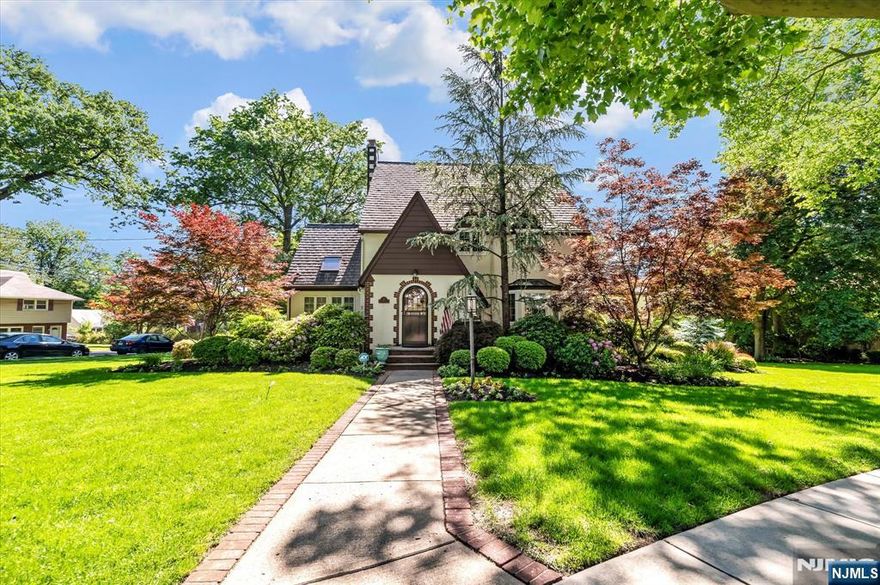 Here is a unique opportunity to live on one of Teaneck's most prestigious streets. This charming Tudor home offers 5 spacious bedrooms and 4 full bathrooms, blending timeless elegance with modern comfort. The home is adorned with beautiful chestnut woodwork throughout and sits on lushly landscaped grounds, which are beautifully manicured and well known in Teaneck. Upon entering, you're greeted by a grand foyer that leads to a generous living room with a cozy fireplace and French doors opening to a raised patioâ€”perfect for outdoor entertaining. The bright den, featuring side-by-side windows and skylights, offers a serene space for relaxation. The formal dining room and custom kitchen provide ideal spaces for hosting, while the separate ADA-compliant EnSuite, with its own bedroom, office, and full bath, ensures added versatility. Upstairs, the bedrooms are generously sized and offer ample privacy, with the Primary Suite serving as a true retreat, complete with a spa-like bath on the upper level. The finished basement, with its own separate entrance, offers great potential as an office or even a 6th bedroom. The home also includes a two-car attached garage, whole-house generator, and plenty of storage. Conveniently located near houses of worship, shops, schools, and Holy Name Hospital, this home is both a sanctuary and a prime location for modern living.