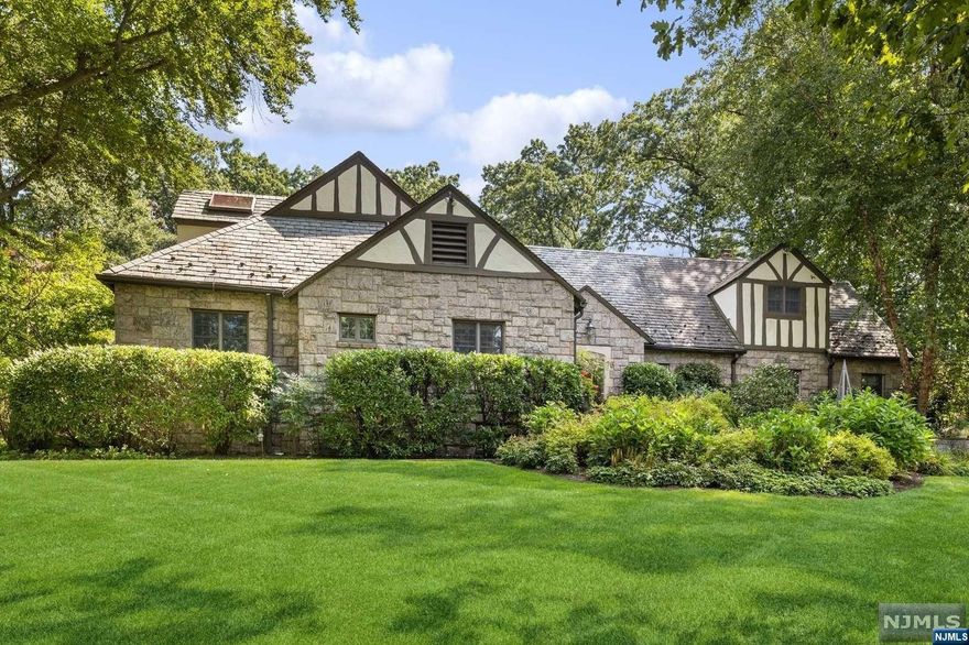 ONE OF A KIND ESTATE HOME with Vermont granite stone exterior offers a lovely blend of period details & contemporary finishes. Chef designed kitchen features custom cabinetry, dual islands with quartz, a wb pizza oven, high-end appliances & both breakfast & skylit sitting areas. Grand living spaces include a vaulted-ceiling LR w wb fireplace & French drs opening to extensive blue stone patio. The DR, also with French drs opening to patio, can accommodates 12. FR boasts a beautiful cherry wood bar. Convenience reigns on the 1st flr with 2 offices, BR suite, laundry & back staircase. Primary suite is a lux retreat with wb fireplace, lg WIC & spa-like BA. Renovated BAs, generator, landscape lighting & security features enhance modern living. Outdoors, enjoy nearly an acre of property with sports court, perennial gardens, hot tub & stunning blue stone patio. Nestled near Yantacaw Brook, Tuers & Brookdale Parks. Convenient to U Mtc's appealing restaurants, shops & transportation.