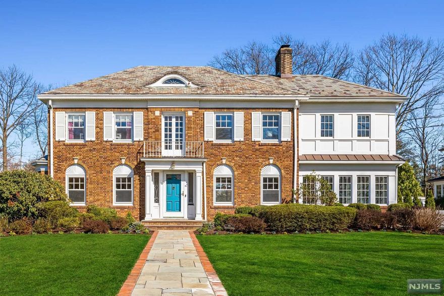 Welcome to this stately brick Georgian colonial situated on almost half an acre! This 5-bed, 5 & a half bath home has it all! Spacious 1st floor incl dining room, chef's kitchen w/ center island & designer appliances, LR w/ fpl & family room. Don't miss the full bath w/ outdoor access for swimmers & sunbathers! Sunroom w/ radiant stone floor, natural light & French doors to covered porch w/ infrared heaters for year-round enjoyment. Hot tub, pool & fenced yard steps from outdoor kitchen w/ oversized grill, 2 refrigerators & lg granite island. 2nd floor includes primary bedroom w/ spa-like en-suite bath, dressing room & Juliet balcony, second bedroom w/ en-suite bath & 2 addi'l bedrooms w/ Jack & Jill BA. 3rd fl w/ 5th BR & marble bath. Finished basement w/ walkout to grounds has room to play, temp-controlled wine rm, home office area, half bath & add'l laundry. Jitney on Ridgewood Avenue to NYC train.