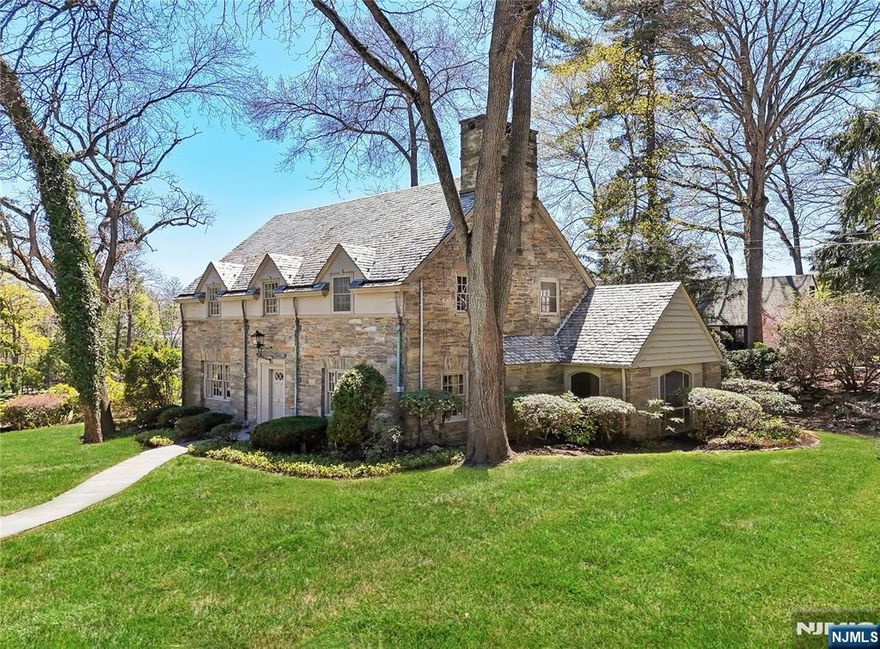 Experience timeless charm in the heart of Ridgewood! Nestled in an enclave of luxury homes on 0.4 acres, this quintessential 5-bedroom, 3.5-bath colonial is brimming with storybook charm and potential. The stately exterior welcomes you into a classic center-hall layout with traditional architectural features. Off the entry foyer is a spacious living room with a fireplace and a formal dining room with elegant millwork. Completing the 1st floor are a library, enclosed patio, an eat-in kitchen connected to stairs to a guest bedroom/home office and a powder room. Upstairs is an ensuite primary bedroom, 3 additional bedrooms and a hallway bath. Enjoy the finished basement, hardwood floors throughout, high ceilings, private backyard and attached 2-car garage. The ultimate opportunity to live in an A+ location, just blocks from Ridge Elementary School, George Washington M.S., the Ridgewood train and bustling downtown!