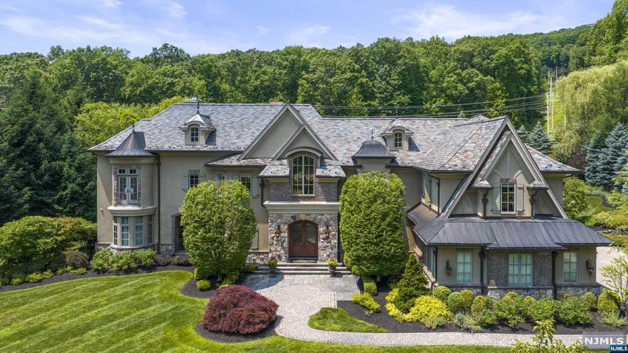 Elegance, luxury & perfection define this estate in the desirable neighborhood of "The Pond" in Montville Twp. Grand entrance welcomes you showcasing custom woodwork & architectural brilliance. Open floor plan seamlessly connects each space, beginning w/ a custom bar room featuring coffered ceilings & built-ins. Formal dining room adjoining a butler's pantry is perfect for entertaining. Great room boasts cathedral ceilings, wood-burning fireplace & stunning arch floor-to-ceiling windows that open to a beautiful patio. The highlight of this home is the kitchen, equipped w/ 2 center islands, quartz countertops, state-of-the-art appliances, pizza oven, separate eating area w/ gas fireplace & an abundance of windows. 1st fl includes a full theater room, game room, bedroom w/ full bath & mudroom w/ custom built-ins. 2nd level, the primary bedroom suite offers a gas fireplace, walk-in closet w/ center island & lavish bath.The outdoor area is perfect for entertaining, w/ built-in kitchen