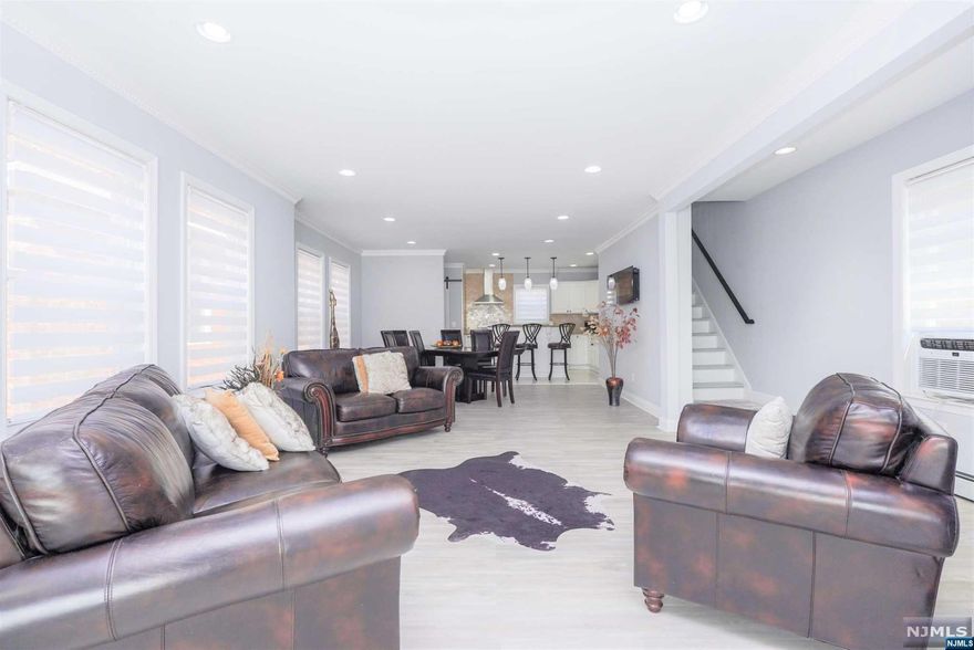 This excellent home is ideally situated just minutes from both the Washington Bridge and Lincoln Tunnel, offering easy access to transportation in a desirable area. The exterior may appear unassuming, yet the interior will astonish you. The ground floor boasts a true open concept, showcasing a spacious living room, dining room, and a astonishing kitchen enhanced by a center island. An elegant half bath adds convenience for guests and social events. The upper floor hosts three large bedrooms, each with ample closet space, and another beautiful bathroom equipped with high-end fixtures and a walk-in shower. The basement is a highlight, offering a family room and a striking wet bar, perfect for entertainment. It also includes a full bathroom and a side door to the backyard, ideal for warm summer days, plus a spacious garage at the driveway's end. This home merges convenience, luxury, and entertainment, making it exceptionally unique. Hurry it won't last!