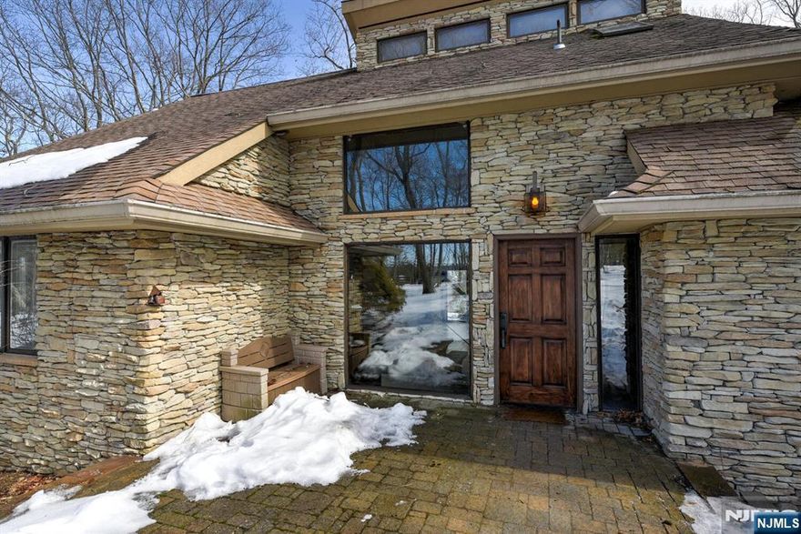 Enjoy breathtaking mountain and sunset views from the wraparound deck of this spacious custom-built Colonial located in the beautiful, gated community of Smoke Rise. This home offers an open and inviting floor plan filled with natural light, skylights, and large sliding doors throughout. Features include hardwood floors, two wood-burning fireplaces, built-ins, and an updated kitchen and bathrooms. The large eat-in kitchen offers a center island, with abundant cabinetry, separate dining area, stainless steel appliances, and sliders to the deck - perfect for entertaining. The first level includes a private ensuite bedroom with a contemporary chic master bathroom, including a glass tub, along with a formal dining rooms and large living room - all leading to a wrapped around deck The second level features two additional bedrooms with cathedral ceilings, generous closets, and an updated full bathroom. Additional highlights include a fully finished walkout basement with a wet bar, extra bedroom, a spare room and an oversized two-car garage, abundant storage, a large circular driveway with plenty of parking, and a newer central air system (2025) with multi-zone cooling. Residents enjoy all the amenities that Smoke Rise has to offer, including 24-hour security, lake access, beach, boating, fishing, tennis courts, sports fields, clubhouse, restaurant, and more. Conveniently located near major highways, NJ Transit, parks, shopping, and top-rated schools.