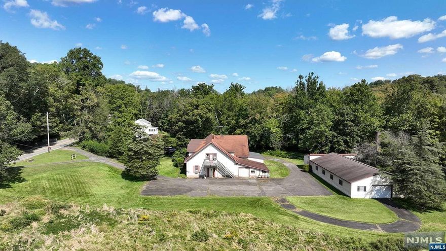 Large Saddle River 10 +/- acre parcel along West Saddle River Rd. bordered to the east by the Saddle River. lower level has Antique restoration work area, Antique sales shop, 2 - 1/4 bths and tandem garages. 2nd level Living area has LR, Fam Rm, Din Rm, Kit, Off, Bed Rm, Fbth, Lndy Rm, Walk-in-closets. There is a large masonry 12 + car detached garage for antique car storage and work shop. Large macadam parking area, circular driveway and vast area of natural fields. Potential use for horses, agriculture, car collector, nature lover etc. Property is located in the R-1 residential zone and in a AE designated flood plain/area. Any determination as to allowable use or required variences to be the responsibility of the buyer. Improvement will require up date/renovation Call listing agent, John "Jack" Sciortino for all showings or to walk the property.