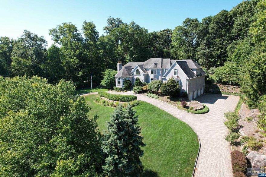 Exceptional build quality and exquisite design details come together within this 6600+ sf Saddle River home. Upon entering, you are greeted by a two-story foyer complete with a custom cherry wood floating staircase. Elegant millwork is on display throughout. The vaulted ceiling great room has a stone fireplace and a custom wood bar. The study features a wood coffered ceiling. The formal living room with fireplace and lighted tray ceiling sits across from a large formal dining room. The Ulrich designed kitchen showcases beautiful walnut cabinetry, state of the art appliances and a breakfast nook. A dramatic entryway leads to a spacious first floor primary bedroom suite. The upstairs bedrooms have en suite baths including a 1200+ sf suite consisting of a bedroom, sitting room, bathroom and bonus room (5th bedroom/home office/nursery/or whatever option you desire). A custom floored 4-car heated garage and gas generator are just a few of the many features and amenities awaiting you.