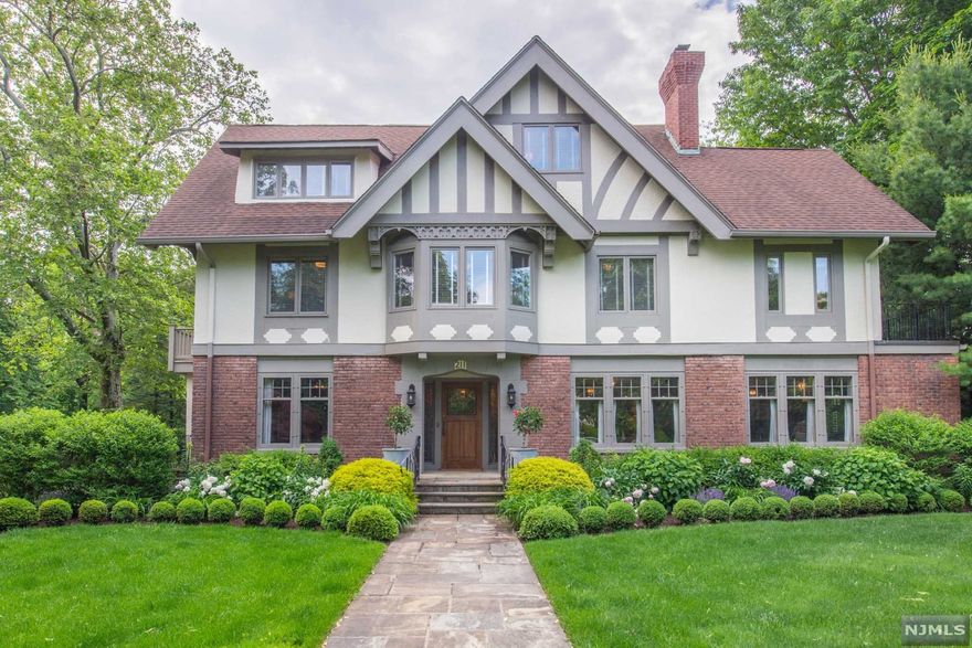 Welcome to this sophisticated, elegant, 7 bedroom 4.1 bath, A.F. Norris style Tudor in historical Erwin Park area. The interior is professionally designed and includes a grand entrance foyer (with fireplace) between the library and dual living rooms (with dual marble fireplace). Well suited for entertaining, the living rooms lead to a family room and formal dining room, both with French doors to a wrap around deck, overlooking the expansive property, gardens, gas firepit and patio. The kitchen boasts a Wolf cooktop, Subzero refrigerator, Miele built in coffee system and a wine refrigerator. Granite counters with a marble island and separate dining area which also has deck access. Luxuriate in the second level primary suite with fireplace, Calcutta marble bath with jetted tub and shower, adjoining the office/sitting room with access to a private veranda. Three bedrooms, one with a Juliet balcony and marble bath complete this level.