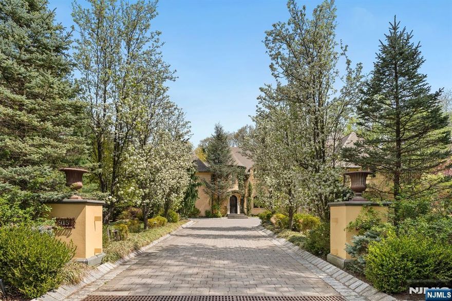 European-inspired elegance defines this French chateau-style estate in Alpine. Built in 2008 and set on 1 acre with mature trees and deep setbacks, it offers approximately 8,000+/- SF across 3 levels (excluding 3-car garage). Features include 6 bedrooms, 5 full + 3 half baths, slate roof, copper gutters & architectural details throughout. Arched doorways, vaulted ceilings & Venetian plaster walls frame an open kitchen/family room with Wolf & Thermador appliances & walk-in pantry. The dining room offers southern exposure views, oversized windows & glass doors to alfresco dining. A 4-season sunroom adds year-round appeal. The sunlit primary suite features a vaulted ceiling & 2 expansive custom WICs. The lower level includes a gym, wine alcove, wet bar, guest suite & recreation room. Outside: heated gunite pool, outdoor kitchen, fireplace & tree-lined seclusion. Tenafly HS district, mins to NYC.