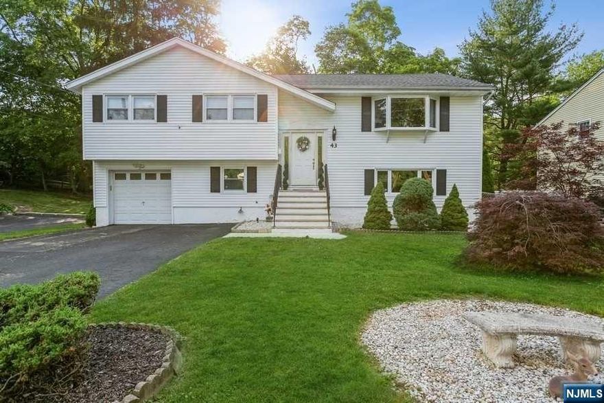 Perfect home to own and/or rent. This spacious bi-level home is set on a quiet cul-de-sac and features a bright, modern eat-in kitchen with granite counter tops, SS appliances and tile floor, formal dining room with sliders leading to lovely deck overlooking private yard, living room with bay window, dining room, 2 bedrooms, full bath and master bedroom with full bath complete this level. The lower level offers a summer kitchen, family room, 2 spacious bedrooms, full bath, laundry, and access to garage. Central AC, multi-zone heating, fenced-in, park like property. Conveniently located close to NYC transportation, and all that the lovely town of Westwood has to offer.