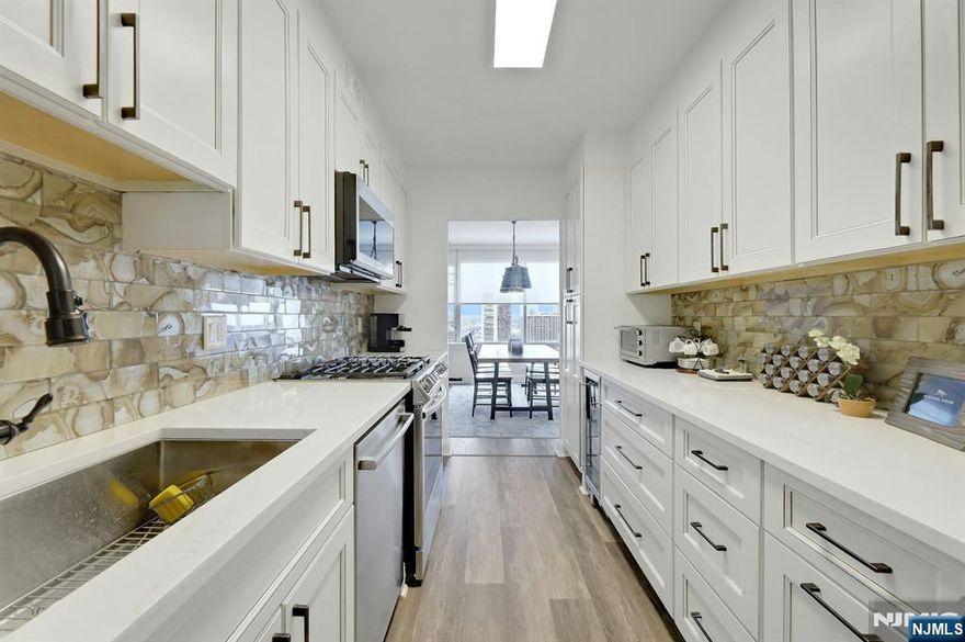 CONTACT DEBRA JACOBS & HALLEY NATKIN DIRECT COLDWELL BANKER FORT LEE. THIS IS THE ONE at Horizon House. A 2 bedroom, 2 bath split layout with no stairs and true private suites. Approximately 1,474 square feet where light, space, and skyline take over. Every window pulls you toward sweeping views of the George Washington Bridge, the Hudson River, and the Ramapo Mountains. The feeling is calm, elevated, and unmistakably special. The designer kitchen anchors the home with custom cabinetry, quartz countertops, Samsung, LG, and Bosch appliances, a glass tile backsplash, and a wine refrigerator made for slow evenings and easy hosting. New luxury vinyl flooring flows throughout. Crown moldings, new doors, custom blinds, and Elfa closet systems create a refined, finished look without excess. A premier deck parking spot (#10 ) transfers with the unit. ONE MONTHLY FEES COVERS EVERYTHING-Utilities, taxes, amenities, and parking are all included $3049.38 (Maint $2316.14,Cap Ass $562.50,Cbl/Int $71.54,Deck Park $79.20,Ameni$20) Full-service living with a 24 hour doorman, security, community room, gym, two pools, tennis courts, play areas, and an on-site convenience store. Board approval is required. Income to debt ratio 4 to 1. Gross income requirement for an all-cash buyer with no debt is $146k. Steps to transportation. Minutes to NYC. This is where coming home feels right every single time.