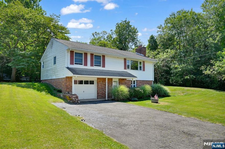 Charming Split-Level Home With Mountain Views, Minutes From Town Center! This Inviting 2 Bedroom, 1 Bath Split-Level Home Offers Timeless Character And Functional Living Spaces Ready For Your Personal Touch! The Main Level Showcases Original Hardwood Floors Throughout The Spacious Living Room, Dining Area, And Bedrooms! Enjoy Cooler Months With The Wood-Burning Stove Insert Set In A Classic Brick Fireplace, All While Soaking In Natural Light And Scenic Mountain Views From The Oversized Living Room Window! The Retro-Style Eat-In Kitchen Features Warm Wood Cabinetry, A Built-In Hotpoint Electric Cooktop And Wall Oven, And A Walk-Out To A Large Backyard, Perfect For Creating Your Dream Outdoor Space! Downstairs, A Versatile Den/Rec Room With A Closet Offers Great Potential For A Home Office And More! You'll Also Find Access To A Generous Unfinished Storage/Workroom, Complete With Laundry, Utility Access, A Workbench Area, And Entry To The 1-Car Garage! Additional Highlights Include: Brand New Furnace (Installed May 2025), Public Water & Natural Gas, Well-Sized Bedrooms With Ceiling Fans And Closets, Full Bathroom With Tub/Shower Combo And Extended Vanity, Private Yard With Trees Coverage And Patio Potential! Minutes From Shopping, Dining, Schools, And 1.2mi From NJ Transit Park & Ride To NYC Commuter Route! Whether You're Looking For A Simple Refresh Or Full-Scale Renovation, This Home Is Bursting With Potential And Charm! Don't Miss This Opportunity To Make It Your Own!