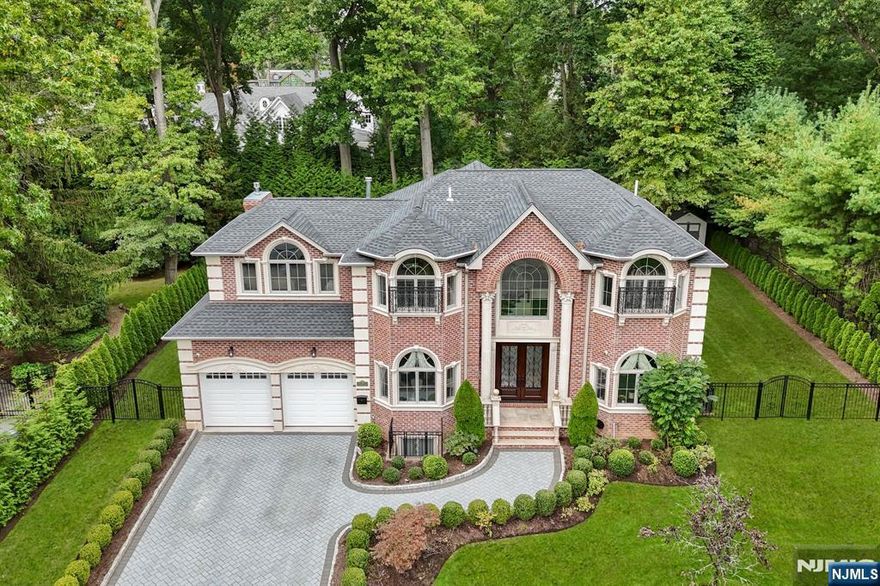 Welcome to this exquisite brick estate on Tenaflys East Hill, offering refined elegance and modern luxury. This 7BR, 5BA home offers an exceptional blend of luxury living & thoughtful design, filled w/natural light. Double iron/wood doors lead to a 2 story foyer w/radiant heat tile floors & extensive molding. The main level boasts HW floors, LR w/coffered ceilings & large windows, DR w/butlers pantry incl. wine storage & fridge. Chefs EIK offers heated tile floors, center island w/2nd sink, Wolf/Sub Zero appliances, & dining area w/sliders to yard. EIK opens to FR w/floor to ceiling windows, high coffered ceilings & gas FPL. 1st fl BR/office & full BA w/WI shower complete the level. 2nd fl offers 4 spacious BRs incl. primary suite w/gas FPL, dual WICs, spa like BA w/double vanity, jetted tub & steam shower. Addl BRs share J&J Bath. Lower Level features theater, rec area, 2 BRs/offices, full BA, & storage. Yard offers paver patio, privacy trees, & 2 car heated garage. Minutes to NYC.