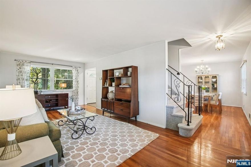 Welcome home to this charming 4 bed, 1.5 bath Colonial in the desirable Oak View neighborhood of Bloomfield. The first floor boasts a bright living room, formal dining, and a sparkling white eat-in kitchen with stainless steel appliances, pale granite, and white oak flooring. A convenient powder room is also on this level. Enjoy beautiful hardwood floors in the living and dining rooms, newer thermal windows, recessed lighting, central air, and excellent closet space throughout. Upstairs, you'll find four spacious bedrooms and a full bath with a tub shower. The finished basement offers a fantastic bonus area perfect for a playroom or rec room. Head outside to a beautifully landscaped backyard with a spacious patio and mature trees, creating a peaceful, private oasis. A one-car attached garage and a wide driveway with space for two more cars complete this perfect picture. Plus, you're just moments away from shopping, major highways, and NYC transportation.