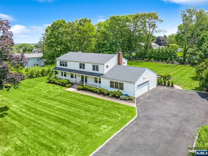 This is it, your search is over! A classic Center Hall Colonial set on lush, flat grounds in Woodcliff Lake is finally here. Step inside to discover elegant formal living rm, dining rm w/fireplace. The modern eat-in kitchen is a chef's delight, featuring top-of-the-line appliances & a center island that offers both seating & preparation space. A spacious breakfast area with an exterior door seamlessly opens to the park-like grounds. This open, flowing space leads to the great room, which boasts another cozy fireplace and dbl sliding doors that open directly to the gorgeous backyard. A versatile first-floor office, a convenient laundry room, and a powder room complete the main level. Retreat upstairs to the spacious primary bedroom, featuring a walk-in closet, bath and separate makeup vanity area. Three additional bedrooms offer plenty of closet space and an abundance of natural light from their numerous windows. An updated hall bathroom with a double vanity adds to the home's thoughtful design. The heated lower level expands your living space with a family room and a versatile bonus room, along with ample storage space. Throughout the home, you'll find gleaming hardwood floors, detail trim work, large windows, soaking the interiors in natural light, closets galore, central vac & so much more. Exterior features include a spacious front porch with double entry doors and a beautiful rear bluestone patio, perfect for entertaining. Come fall in love!