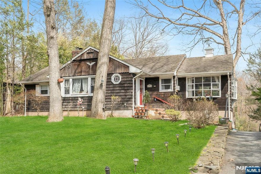 Nestled on an extremely large, private parcel within a beautiful wooded setting, this expansive ranch home offers the ultimate sanctuary. Positioned directly across from the Ramapo Mountain Reservation State Forest. This is a rare opportunity for outdoor enthusiasts to live where they love to play, all while enjoying easy access to major highways. Step inside to discover a warm and inviting main level bathed in natural light from skylights and highlighted by classic hardwood floors. The updated kitchen is equipped with stainless steel appliances and a pantry, flowing seamlessly into a separate dining area. Gather in the spacious living room, anchored by a cozy wood-burning fireplace, or retreat to the sunroom to soak in the serene, wooded views. The finished basement features recreation room complete with a stylish wet bar (decorative sink) and a cast-iron wood-burning stove. This lower level also includes a full bathroom, a laundry room, an office/4th bedroom and a utility room. This home also has a 1 car built-in garage and a large driveway with easy turn-around. Critical updates include above ground oil tank & 1000 gallon tank septic system installed in 2022 and brand new water softener filtration system installed in 2026. Donâ€™t miss the chance to own this exceptional property where nature meets convenience. Listen to the sound of your own brook in the back yard and enjoy the fire pit for those cool evenings. Sold as it is. Motivated sellers and present all offers!