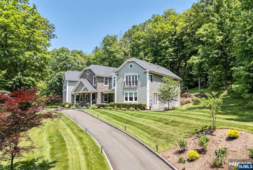 Discover the epitome of elegance at 1 Tanbark Trail, where sophistication meets comfort in this exquisite Hampton-style colonial home. Nestled in a tranquil cul-de-sac on two acres of pristine land, this residence offers unparalleled privacy and luxury. This young home features five generously sized bedrooms and four and a half exquisitely appointed bathrooms, ensuring a refined living experience throughout. You will be captivated by the custom-designed kitchen, a true culinary haven featuring a spacious island and top-of-the-line appliances from Miele, Sub-Zero, and Wolf. The kitchen flows seamlessly into the dining room and an expansive living area, where French doors open to extend your living space outdoors. The second floor presents a versatile bonus suite, perfect for guests, a game room, or additional living space. With three bedrooms offering en-suite baths and two sharing a Jack and Jill setup, comfort is paramount. The primary suite is a retreat in itself, featuring a two-room configuration, a Juliet balcony, fireplace, en-suite bathroom with separate soaking tub and a luxurious walk-in California Closet. Experience seamless indoor and outdoor living with beautifully landscaped grounds and serene patios ideal for entertaining or relaxing. The outdoor fireplace enhances the inviting atmosphere of this elegant home. 1 Tanbark Trail isn't just a home; it's a lifestyle of tranquility and elegance, making it a true gem in Saddle River.