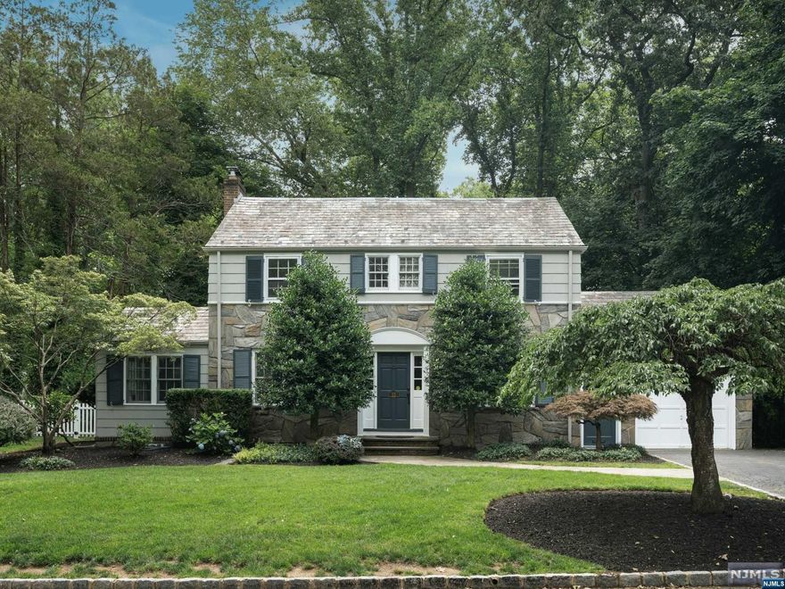 Located on a favorite tree-lined street, this 1931 fieldstone Col is storybook charming & freshly updated. Beautiful details found on the 1st floor include wainscotting in the formal DR, wide moldings & a beam & board ceiling in the sunroom. The EIK with stainless appliances and granite counters opens to the large deck & flat yard surrounded by mature trees & landscaping perfect for quiet mornings or end of day relaxation. A powder rm & mudrm off the garage completes this level. The 2nd flr offers a large primary w/ updated en suite bath, along with two additional bedrooms and a stylish hall bath. The immaculate basement has a large finished playrm/rec rm, a discreet powder rm, utility rm, and laundry, perfect for fun activities & storage needs. With CAC & a fresh interior, this 1931 home blends the charm of the past with modern comforts, making it ready for modern living. Applegate Farms Ice Cream, NY transportation, parks & Upper Montclair shopping & dining are all nearby.
