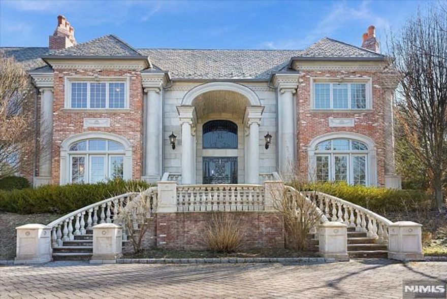 Minutes to Manhattan, this Alpine estate on a private cul-de-sac street on 2.35 AC. Timeless elegance and unparalleled luxury. Quality crafted, this gated masterpiece boasts a stately slate roof, a sweeping circular driveway, and an opulent indoor pool all creating an ambiance of sheer refinement. A grand two-story entrance foyer w/ marble detailing. Main level has a mahogany wood library featuring a coffered ceiling and Fpl, a regal formal dining room with its own fpl and butler's pantry, and a sprawling great room w/ fpl, custom built-ins and Fr. doors to inside and outdoors. A professionally designed kitchen, complete with cozy breakfast and sitting areas, sits at the center of the home, w/ Fr. doors to private patio. An en suite guest bedroom, a spa-like pool area and 1/2 bath complete the main level. Second level has two luxurious primary suites and 3 additional bedrooms. Lower level has outdoor access, home theater, bar, great room. Elevator. Much more!