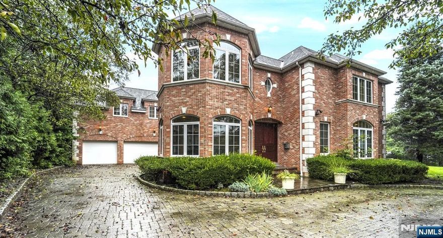 Located in Fort Lee's desirable Bluff section, this expansive 5 bedroom, 7.5 bath center hall colonial is situated along the Palisades Cliffs w/NYC & Hudson River views from almost every room. Over-sized property. 2-story entry foyer. Open layout w/windows along the entire back of the home highlighting the views! 1st floor features a home office w/gas fireplace, family rm, DR, gourmet EIK w/granite countertops, SS Viking appliances & wine fridge, full bath, laundry room & formal LR w/fireplace. Attached 3 car garage. Large MBR suite w/sitting room, fireplace, large full bath, 2 enormous walk-in closets & dressing area. 3 additional BRs each w/full baths. Huge finished basement offers an office, rec room, additional BRs, and 3 more full baths. At approximately 5,500 sq. ft., this home offers a private oasis with quick & easy access into NYC.