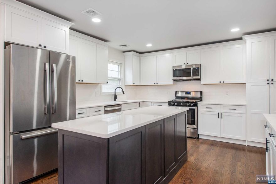 Beautifully renovated bi-level home featuring a fresh two-toned kitchen with a large center island, along with updated master and main baths on the second level and renovated powder room on the lower level. Enjoy an open floor plan connecting the living, dining, and kitchen areas, perfect for modern living and an oversized 2 car garage. Plus, benefit from the efficiency of a new Navian tankless water heater.