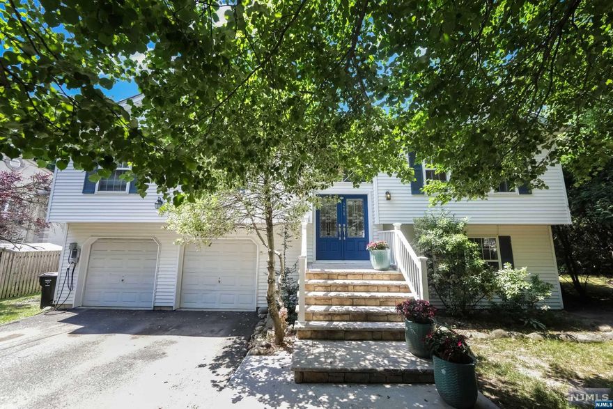 Lovely spacious Bi-Level style home located in Prime Paramus location on a huge property Features 4 bedrooms, 3 full bath. On the first floor enter to a spacious living room with Vaulted ceiling, formal dining room and a large eat-in kitchen with high ceiling, skylights and an exit to a brand new deck. Primary bedroom has a large Primary bath, there are two other spacious bedrooms and a full bath. Lower level features a bedroom, full bath, family room with an exit to the yard, a laundry room and two car garage. Situated on a large private property, in proximity to NYC bus, shops, schools and parks. Enjoy this well maintained custom built home and Paramus with low taxes and all it has to offer. Large parking space enough for 6 cars plus 2 car garage. Additional Parking across the street. Car charger is included.