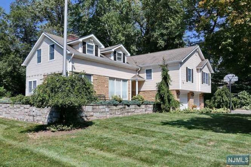 PERFECT FOR PRIVATE HOME OFFICE OR GUEST SUITE with private entrance, living room, kitchen, bedroom, full bath, and laundry. This beautiful tri-level offers 4 additional bedrooms, 3 updated full baths, lovely kitchen,large pantry room, formal dining room with sliders to patio, formal living room/fpl. Ground floor family room with sliders to patio, full bath, mud room, laundry, and access to 2 car attached garage. Finished basement with fpl, utility room, and plenty of storage space all set on a quiet street with a tranquil private patio with gas fire pit, built-in seating, and deep yard. Great location! Excellent schools! Close to NYC transportation.