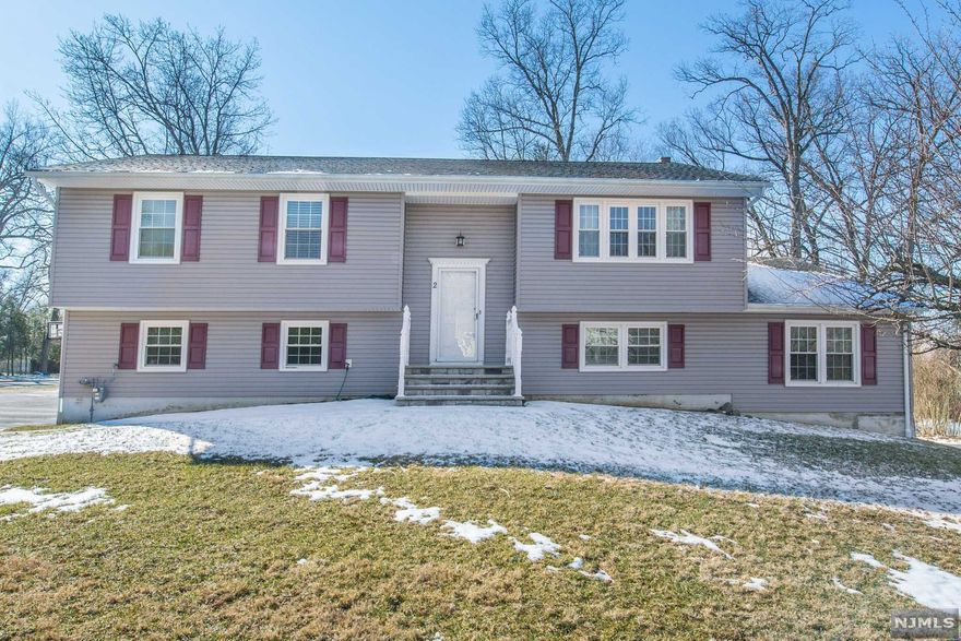 Welcome to this over sized bi level with a full in law suite. Upper level is 3 bedrooms including a master bedroom with updated bath and walk in closet. Living room, dining room and eat in kitchen Hardwood floors throughout the upper level. The lower level consists of a 2nd kitchen, very large bedrooms and a family room with laminate flooring and a wood burning fireplace. Updates inc. Newer vinyl siding , roof, windows and water heater. 3 car garage. Close to the highways and NYC transit.