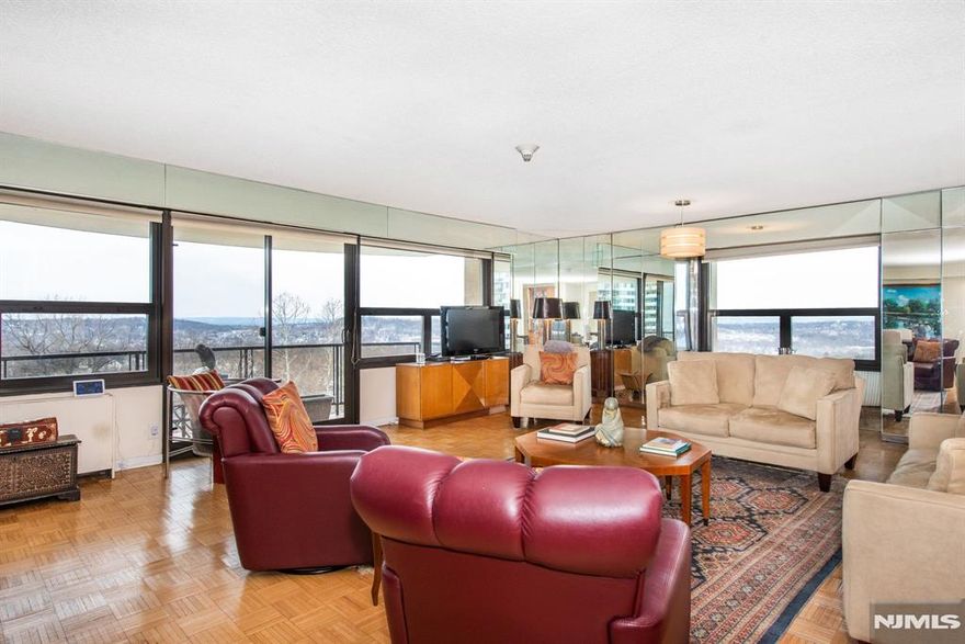 Experience refined living in this exquisite open-concept end-unit condo, filled with natural light and designed for effortless entertaining. The spacious living and dining areas feature expansive Thermopane windows and sliding doors that showcase sweeping panoramic sunset views over rolling hills and a serene, wooded landscape. Step outside to your private balcony - perfect for unwinding at dayâ€™s end. The adjoining eat-in kitchen offers sleek white cabinetry, granite countertops, appliances, and the convenience of an in-unit washer and dryer. The primary suite includes two walk-in closets, a dedicated dressing area, and a private en-suite bath. A second bedroom easily adapts as a guest room, home office, or den. Recent upgrades include neutral carpeting and fresh paint throughout. A floor-level storage unit provides additional storage. Monthly maintenance covers all utilities. Residents enjoy an exceptional suite of amenities, including 24/7 concierge and valet service, party and card rooms, a library, a full-building backup generator, a fitness center with saunas and showers, a heated Olympic-size pool, a BBQ area, a 7-cup putting green, a tennis court, and a basketball/pickleball court. Ideally located near major highways, NYC bus routes, and the Montclair train station, with shopping, dining, and parks just minutes away. A timeless yet contemporary home - make it yours today! Sale As- Is.