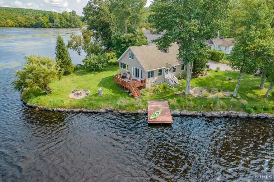 This outstanding peninsula property has breathtaking lake views from every window in the home displaying its 285' of lakefront living at it's best. Log accent beams complete the authentic lake house experience, bringing the outdoors in. Enjoy the sights and sounds of nature with glimpses of wildlife and spectacular sunset views. Cantilevered dock on the property just steps from your deck. Recently renovated large eat in kitchen bathed in natural light, complete with high end appliances and farm sink. Very large open loft. Furnace, hot water heater, central A/C have all been upgraded since 2016. Two-story stone chimney with newer hearthstone high efficiency wood burning insert (2016). The landscaping is home to mature apple trees, blueberry bushes, grape vines, lavender, tulips, Russian sage, rhododendron, and butterfly bushes. Private Road.