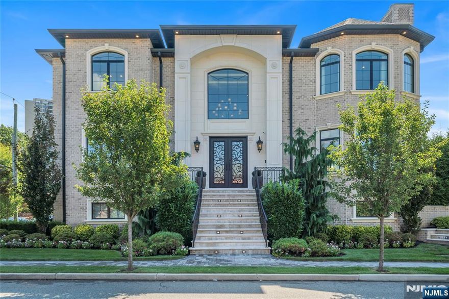 This striking three-story contemporary brick home located on a desirable corner lot in Fort Lee was built in 2020, it offers an exceptional blend of modern design, spacious living & high-end finishes throughout. The ground floor features a large recreation room along with a dedicated wine room, a full bathroom and a stylish wet bar. A practical mudroom provides everyday convenience, while the attached three-car garage offers ample space. On the main level, you'll find a welcoming main entry that opens into a sunlit living room, formal dining room and a bright front room ideal for sitting area or home office. The gourmet kitchen is equipped with modern appliances, generous counter space and a walk-in pantry w/ direct access to the backyard. A second wet bar and powder room complete the 1st floor, making it ideal for both everyday comfort and entertaining. Upstairs, the home features a spacious primary suite and a walk-in closet and a luxurious en-suite bathroom. Three additional bedrooms offer plenty of space for family or guests, accompanied by two well-appointed full bathrooms. A conveniently located laundry area with washer and dryer completes the upper level. Additional highlights include central multi-zone air conditioning and heating, with radiant heat in bathrooms. The home has a durable and elegant full brick exterior and abundant natural light throughout. Conveniently located near top-rated schools, parks, shops and just minutes from New York City.