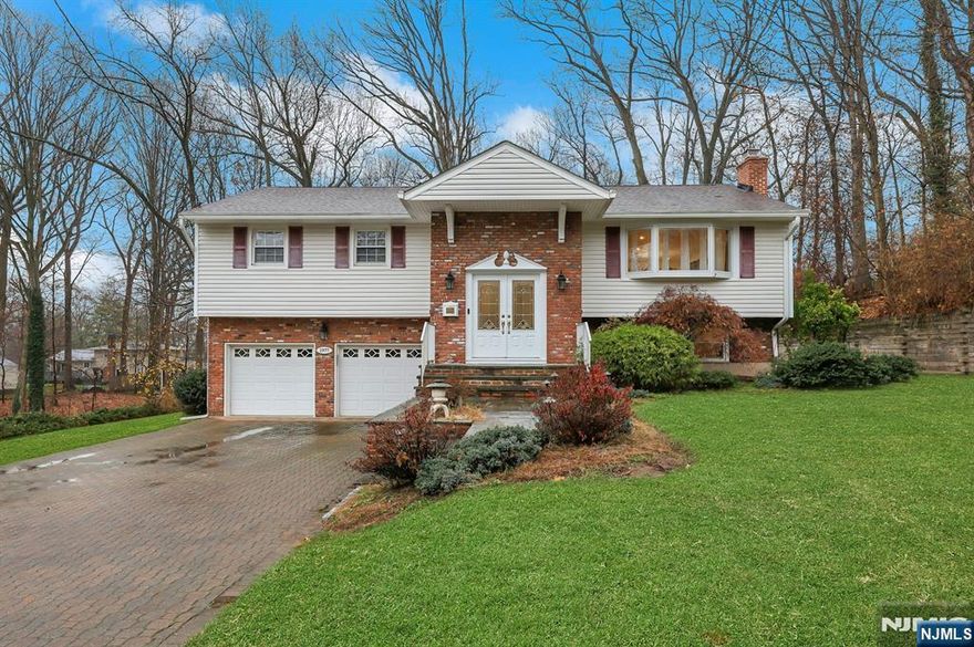 Located in Desirable West side of town is this Immaculate, Sunny, Spacious 4-bedroom. Beautiful paver driveway welcomes you & provides tons of off-street parking. Slate steps lead to the porch and the large entry foyer has an open stairwell with open views to both levels. Main level has wood floors throughout. Large living room has recessed lighting & a large window bringing in morning light. Dining room has sliders with integrated blinds, easy access to very large back deck overlooking the huge private backyard with beautiful shade trees! Kitchen is spacious enough for a breakfast table and has 4-burner cooktop. Large Primary BR has two large closets & en-suite bathroom with walk-in shower & Toto toilet/bidet. 2 family BR's & large bath also on this level. Lower level has warm, inviting Family Room with a wood stove fireplace with a brick wall surround. 4th BR is on this level and has carpet and large window to backyard. Full bath & Laundry includes a standing shower and washer and dryer. Garage access with tons of storage! Beautiful Backyard with so much space! Easy access to Garden State Pkwy , Hwy 17 & only 15 minute walk to High school & steps from center of town. Must See in person!! Truly a pleasure to show!