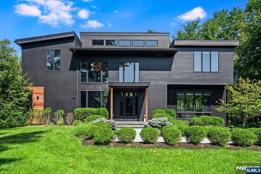 Tucked away on a quiet cul-de-sac in Franklin Lakes, this stunning Industrial Modern home was built in 2018 with top quality finishes and thoughtful attention to detail. The main level features a spacious open floor plan with a dramatic two-story family room centered around a modern fireplace. The high-end Leicht kitchen is completed with a Wolf oven, Miele dishwasher, Sub-Zero refrigerator, and sleek custom cabinetry. Also on the first floor, youâ€™ll find a comfortable sitting room, a full bathroom, and a private guest bedroom that can also be used as a home office. Upstairs, the primary suite overlooks serene natural trails and includes a spa inspired bathroom with a private sauna. The second floor also offers a laundry room, two additional spacious bedrooms, and a full bathroom. The finished lower level provides flexible space for a gym, den, or media room. The home is fully equipped with upgraded features, including beautifully designed bathrooms, a whole house generator, smart irrigation system, indoor/outdoor sound system, water softening system, and a full security camera setup. Enjoy the outdoors with built-in grilling station, IPE Brazilian hardwood deck and a private backyard surrounded by nature offering a peaceful and quiet escape. Conveniently located near transportation, schools, shopping, and houses of worship.