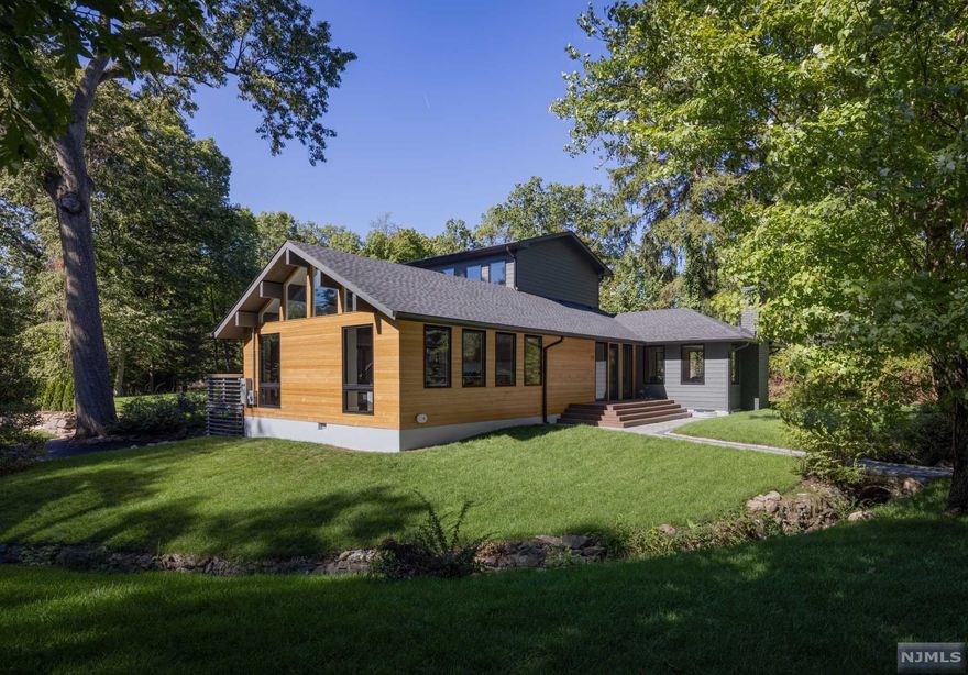 Welcome to this East Hill mid-century modern inspired new construc. just mins from Manhattan! Enter into a bright & open floorplan ft spectacular architectural throughout, expansive windows surrounded by greenery, smart home tech & nat. cedar exterior. Each room is situated to optimize nat'l light, hardwood floors & beautiful cathedral ceilings w/exposed beams. The main lvl is ideal for family living & entertaining featuring a fabulous chefs kitchen open to family rm w/ vaulted ceilings & F2C doors leading out to a your wrap around deck. Dining rm w/ fpl, wet bar & powder rm finish out 1st fl. Next find 2 bdms, hall full bth, lndry & 1 en-suite w/ a private terr. Private 3rd fl is home to an expansive primary suite w/ beamed ceilings, F2C windows overlooking the lush backyard,gas fpl, & private terrace! A home office & walk in closet w/2nd lndry & spa like bath.The LL ft a rec area, large storage closets, 2 car garage access,& mud rm w/built-ins! Builder offering 2 year warranty.