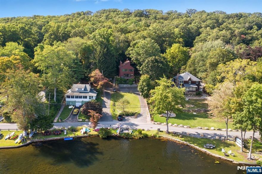 Picturesque Lakefront Location on half an acre on beautiful Cedar Lake! Sitting on top of a wooded property with LAKE VIEWS AND direct, private LAKEFRONT access. Functional floorplan, design, features & numerous windows to create bright living space which enhance the Lake views. The first floor layout includes a large living room with a wood burning fireplace. Smartly designed to give the illusion that extends out onto the oversized front deck from Anderson french doors. Recently renovated kitchen with gorgeous granite countertops and access to the wooded backyard & deck. Formal dining room. Convenient powder room. 1st floor bedroom and full bath. Hardwood floors throughout. Upstairs, 2 generous sized bedrooms both with en-suite full baths. The primary suite boasts cathedral ceilings with large picture windows, a soaking tub & a custom wardrobe with laundry which leads to the updated bath & stall shower. Second generous sized bedroom with wood burning fireplace & full bath with tub shower. Perfect layout for entertaining or just everyday living. Make this home yours! Desirable neighborhood and Cedar Lake community. Private lakefront access & private dock. Beaches, fishing, boating, etc. Just a stones throw from Main Beach & Boat Docks. Easy access to DWTN Denville, major highways & NYC Direct Mass Transit. TONS of Shopping & Restaurants Nearby. Public utilities (Gas on street). -- Also includes lakefront property Block 60906 & Lot 35. New roof in 2012.