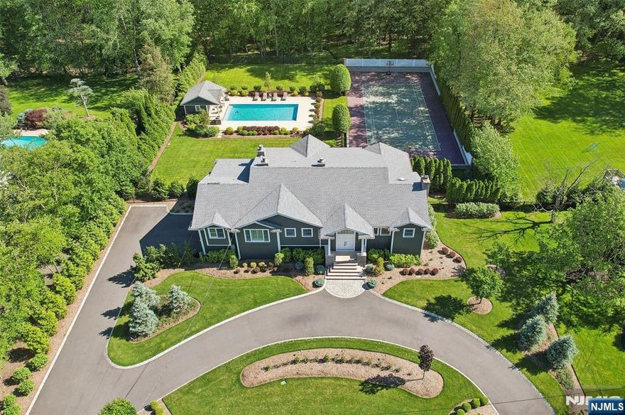 Prepare to be captivated by this magnificent ranch-style estate tucked away on a quiet cul-de-sac. This entertainer's dream home boasts an outdoor oasis with a 20x40 gunite pool, tennis court, pool house with full bath, and an expansive patio featuring a fireplace, dining area, and built-in kitchen. Enter the open floor plan to find high ceilings and abundant natural light streaming through tall windows and glass doors to outdoor balconies. Gourmet kitchen, equipped with Thermador oven/stove, Subzero refrigerator, 2 Miele dishwashers, and oversized center island with wine fridge. Family room with fireplace, den, formal dining room, 4 bedrooms and 3 baths, including a lavish primary suite with fireplace, sitting room, and spa-bath, complete the 1st floor. Lower level offers a living room with floor-to-ceiling windows, bedroom/bath, gym, 2-car garage access, and sophisticated den with built-ins opening to a hidden home office. The ultimate blend of indoor-outdoor living awaits!