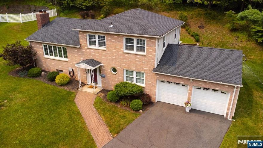 Welcome to this beautifully updated home offering the perfect blend of comfort, space and style! Located in West Orange's desirable Mt. Pleasant neighborhood, across from the Byrne Golf Course. This classic brick-front gem sits on a spacious lot with manicured landscaping, great curb appeal and a gracious front entry. Inside, enjoy an open-concept layout ideal for everyday living and entertaining. The ground level offers a spectacular family room that opens to a custom paver patio and lush yard. A conveniently located bedroom with ensuite bath complete the ground level. The main level boasts a bright living room with a wide bank of window, a beautiful mantel and wood-burning fireplace, open to the elegant dining room with chic lighting and sliders to an expansive deck. The stylish kitchen features white cabinetry, stainless steel appliances and breakfast counter bathed in natural light. The top level offers a spacious primary suite with ensuite bath AND 2 more bedrooms. The finished lower level adds flex space for home office, gym, theater, or playroom plus laundry, powder room and storage. You will enjoy the stunning backyard oasis with oversized deck, outdoor TV setup, paver patio & serene green space. Recent NEW updates include: Furnace, roof, garage doors, patio, carpet and powder room plus recessed designer lighting & gleaming hardwoods. Impeccably maintained - Move right in ! Located 5 minutes away from South Mountain Recreation Complex. Good location for commuters !