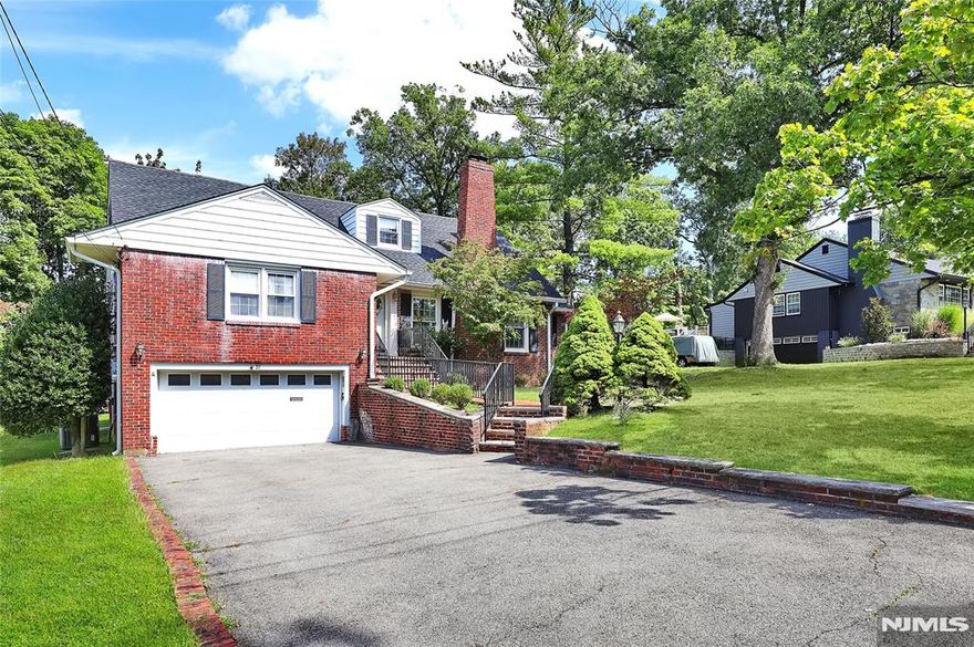 Set on a picturesque, tree-lined street in Great Notch, this brick home offers multiple levels for a versatile floor plan and multi-generational living! A welcoming foyer leads into the formal living room, where a wood-burning fireplace sits against a custom woodwork wall and sunlight pours through the tall windows. Just beyond, the dining room features crown molding, chair rail detailing, and hardwood floors that extend throughout much of the main level. To the side, the family room offers a relaxed setting with built-in bookcases and a picture window. At the heart of the home, the eat-in-kitchen is outfitted with a gas cooktop and a wall oven, warm wood cabinetry, classic hardware and light countertops. From here, a door opens to the screened porch, where indoor and outdoor living meet. With room for both dining and lounging, this airy retreat naturally becomes a favorite gathering place. Two bedrooms on the first floor share a full bathroom while upstairs, another bedroom and the spacious primary suite include two walk-in closets. The lower level is perfect for multi-generational living with a family room, full bathroom, summer kitchenette, laundry, outdoor access, and garage access. Minutes away from public transportation!