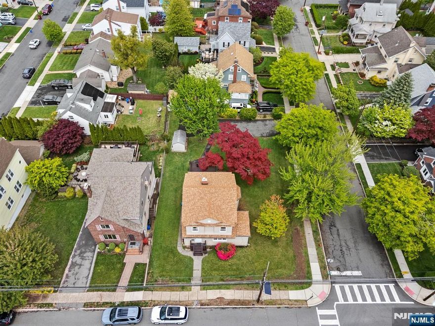 Welcome to this charming 4-bedroom, 2-full bath Colonial situated on a beautiful tree-lined street in Nutley. Offering immense potential, the first floor features an eat-in kitchen, a formal dining room, a full bathroom, and a spacious living room centered around a cozy wood-burning stove. The second level houses four bedrooms and a second full bath. Additional space includes a walk-up attic for ample storage and a full basement featuring a laundry area and utilities. The exterior is perfect for entertaining, boasting a large deck overlooking a corner property. The long, double-wide driveway provides rare off-street parking for 6+ vehicles, complemented by a convenient storage shed. Equipped with wall A/C and ceiling fans for comfort. Ideally located near major highways, NYC transportation, parks, schools, shopping, and local dining.