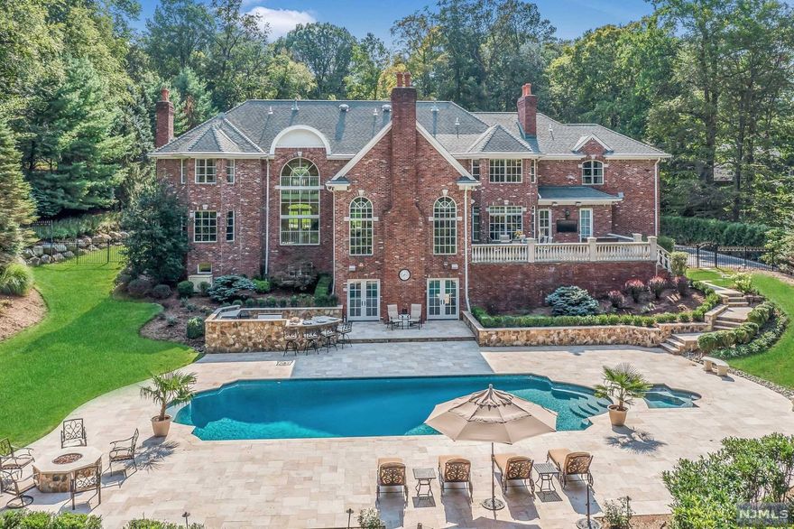 Chic, sophisticated and ultra-private! The lush lawn & tranquil rock waterfall lead you to the covered front porch of this sensational, renovated residence. Grand two-story foyer, elegant dining room that flows into the two-story great room with an open feel, beautiful fireplace, & floor-to-ceiling windows. Work & entertain in your private custom office, bar & billiards room. The upgraded gourmet kitchen features professional appliances, a seated island, outfitted pantry, & an open eat-in area leading to the bluestone patio. The luxurious primary suite has boutique closets, spa bath, sitting room w/ beverage refrigerator, and a gas fireplace flanked with bookshelves. Additional bedrooms and baths are all bright & updated. Five-star lower level offers theater with leather recliners, professional bar, fitness center w/ spa bath, play area, & game room. French doors open to the massive patio with salt-water pool, spa & built-in kitchen with seated island. You'll never want to leave!