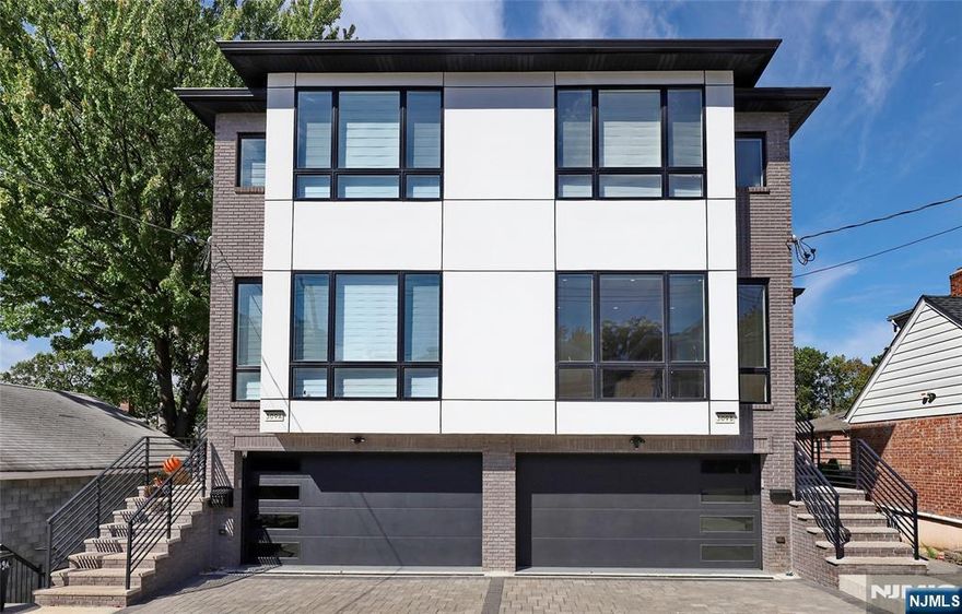 Step into an open floor plan featuring a spacious living room with a cozy fireplace, a formal dining area, and a comfortable family room. The modern kitchen is equipped with top-of-the-line smart appliances, a quartz countertop, and a large center islandâ€”perfect for entertaining. A convenient half bath ,a private balcony, soaring 9-foot ceilings, and beautiful oak flooring throughout further enhance the elegance of this main level. Upstairs, you'll find three generously sized bedrooms and two full bathrooms. The primary bedroom includes a luxurious en-suite bath. Additional highlights include a laundry room, skylights, and gorgeously tiled bathrooms. The ground level boasts 10-foot ceilings and offers incredible flexibility with a large family room, an additional bedroom or office, a full bathroom, and a summer kitchen. Sliding glass doors open to a private deck, and a separate entrance makes this space ideal for guests, extended family, or a home office setup. This home offers a total living area of approximately 3,400 sq. ft., with a 2-car garage. and 2 additional driveway parking spaces. A bonus basement area of 500 sq. ft. provides ample room for seasonal storage or future customization .Conveniently located near major highways for an easy commute. Located in a highly sought-after community with good schools, and just minutes from Broad Avenue for shopping, dining, and NYC transportation. This is a must-see home that truly has it allâ€”space, style, and location