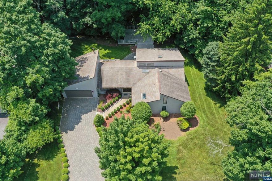 Perched high on the east hill near Alpine's border, this approximately 0.6-acre ranch home offers serene living and modern comfort. Inside, an expansive great room with skylights flows into a gourmet kitchen featuring custom cabinetry, top-of-the-line stainless steel appliances, including a Sub-Zero refrigerator and granite countertops. Adjacent to the kitchen is the dining room and a loft area that can serve as guest quarters or a home office. The primary bedroom boasts an ensuite oversized bathroom with vaulted ceilings. Enjoy morning coffee or alfresco dining in the lush yard with its expansive deck, perfect for entertaining. With ample space and a strategic layout, this property is versatile and ready for expansion, renovation, or a new build to suit your needs. It is located near top-rated schools, a variety of restaurants, the Closter shopping plaza, and offers quick access to the Palisades Pkway, GWB or Mario M. Cuomo Bridge.