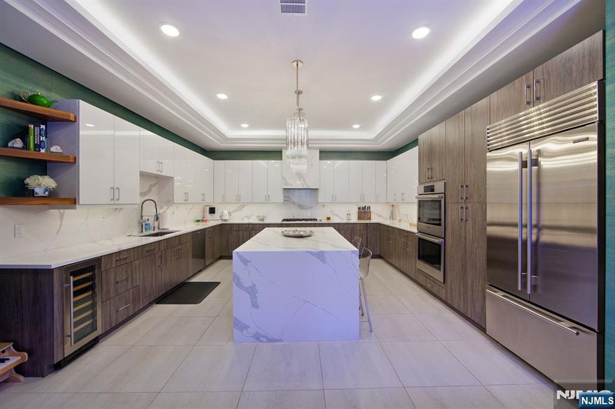 Luxury duplex residence on an oversized lot in Edgewater, NJ, offering breathtaking Hudson River and Manhattan skyline views. Spanning approximately 4,000 sq ft across four levels with 10-ft ceilings, this modern home features 4 bedrooms, 4.5 bathrooms, a private roof deck, and a four-level elevator. The striking stone and stucco facade is accented by black Andersen metal panel windows and a two-car glass garage. Inside, enjoy a full JDAV Media package with wired internet in every room, whole-house speakers, and seamless connectivity. The open-concept living level showcases a wraparound chefâ€™s kitchen with professional appliances, an 8-ft island, and designer finishes. Enhancements include custom window treatments, Lutron dimmable lighting, UV window film, whole-house humidifier, two-zone HVAC, and a hard-wired security system. The second level offers a family room with cove lighting and a dramatic floor-to-ceiling linear fireplace. The third level, includes a primary suite, additional bedrooms, laundry, and access to a landscaped patio. The top floor is ideal for entertaining, featuring a lounge with wet bar, bedroom, full bath, and direct access to the rooftop deck with upgraded flooring, custom planters, and panoramic river and skyline views. An exceptional offeringâ€”video tour recommended.