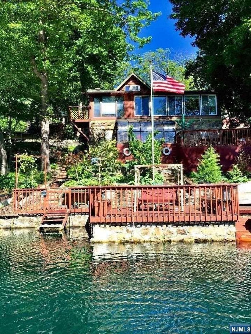 Charming open floor plan lakefront log with gorgeous lake views. Kitchen with maple cabinetry & granite countertops. Living room has a beautiful tongue & groove cathedral ceiling with an original stone woodburning fireplace. There is a separate dining room off of the kitchen which is very spacious for those dinner parties. The primary bedroom opens to a private veranda to sit & relax. The den off of the living room overlooks the lake. There is an upper loft bedroom overlooking the living room & kitchen.The lower-level has a family room, rec room, workshop & laundry room in which you can use as you wish. A second full bath/ laundry room on the lower level.The sunroom will access to the deck give great outdoor living space for entertaining with the private boat dock for relaxing or floating in your non-motorized boat. Beautiful waterfalls to small pond in yard. Swim off your private dock or relax at the walking distance community each.Two bedroom, Septic as per WM Health Dep