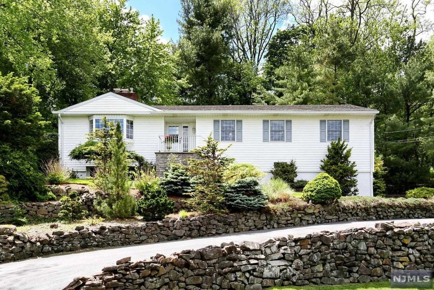 Nestled in the desirable Heights section of Hawthorne with incredible views of the NYC skyline, this home is the true definition of a private oasis. The front entry delights with sweeping views of the area, a bright foyer with newly refinished hardwood floors to a well appointed living room with gas fireplace. The entertainer's dining room, leads to the custom kitchen which boasts beautiful oak cabinetry, an island for cooking/prep, and buffet area with more cabinetry/counter space. The kitchen opens to a spectacular conservatory with domed ceiling and wall to wall windows-an ideal family room- with access to 2 newer paver patios and stunning tiered back yard.The main hallway leads to a primary bedroom with updated bath, 2 more bedrooms, full hall bath and an additional 4th bedroom currently doubling as a laundry room.The lower level with its own living areas, renovated full bath, storage and access to the 2 car garage could be ideal for extended family. Your private oasis awaits!