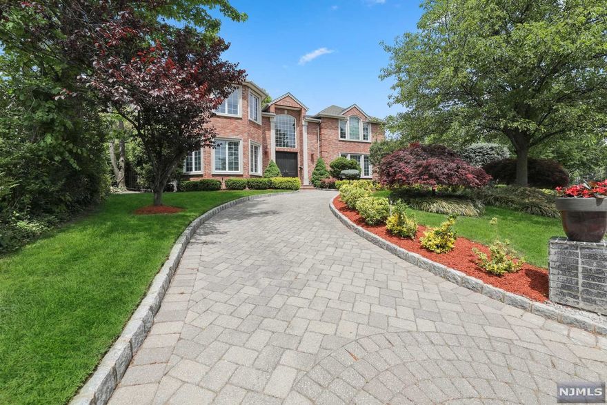 OPPORTUNITY KNOCKS! Stately Brick Colonial set on a corner property in the prestigious North Cliffs in walking distance to NYC transportation. This 5 Bedroom 4.5 Bath home was custom built in 2003 with large bright rooms, oversized windows and high ceilings. The Main Level features a double height Great Room that opens to a Gourmet Kitchen and Breakfast Area. A Living Room,Dining Room, Library/Office,Guest Powder Room and 3 Car Garage complete this level. The Second Level consists of a Master Bedroom Suite with Sitting Room/Office, a Bedroom Suite and two additional Bedrooms with an adjoining Bathroom. The Basement is finished with large windows,a built-in Bar,Exercise Area, Bedroom and a full Bathroom. The rear property is perfect for entertaining with a flat yard and a large paver patio. Radiant Heat - Backup Generator - Low Taxes - Minutes from Manhattan.