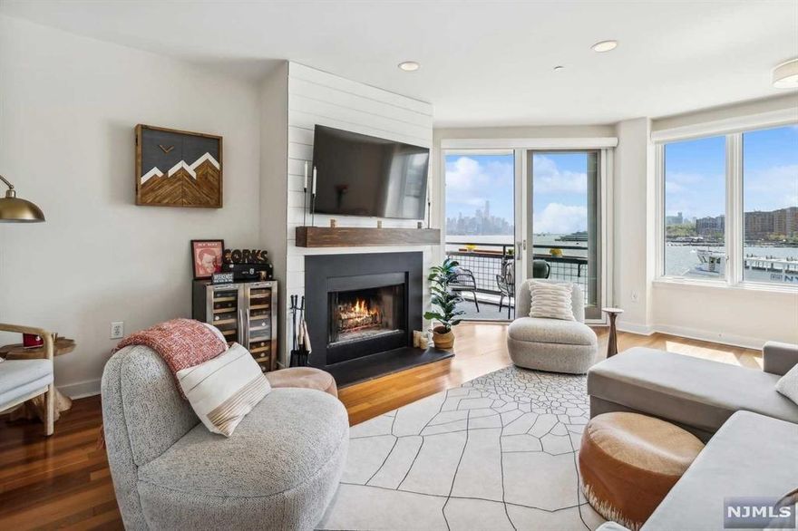 Experience luxury living with this beautiful South-facing, one bedroom, one bath condo, with breathtaking views of both the iconic New York City skyline and the Hudson River. Relax on your private balcony and soak up all the sunshine. This condo offers an open-layout kitchen, a cozy wood-burning fireplace, and an elegant stand-alone tub, as well as a convenient in-unit washer/dryer. Residents can enjoy the building's amenities, including a 24-hour concierge, a state-of-the-art gym, and an indoor pool. Additionally, enjoy the convenience of one-car garage parking. With easy access to Whole Foods, NYC Ferry, Light Rail, and Bus, this is truly an opportunity not to be missed!