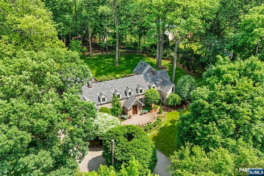 Incomparable home in coveted East Hill neighborhood. Incredibly rare opportunity to own this private, peaceful sanctuary atop 1.4 lush acres on Tenaflys most beautiful street in Old Smith Village. This stone manor features a modern, light filled interior that is the epitome of simplicity & beauty. With 5 BRs & 3.5 bathrooms, room after room reveals gracious spaces to live, work, & play where the magnificent oaks & gardens outside are a soothing backdrop to indoor life. The open, airy floor plan features a show stopping glass staircase, a kitchen open to dining & living spaces, sun drenched office w/ access to courtyard & stunning backyard views from every window. The spacious 3 car heated garage & separate access to the 2nd floor make this the perfect home for any stage of life. The crown jewel is the expansive backyard & courtyard that transports you to the Tuscan hills. Perfect for al fresco dining & a quiet retreat. Located close to NYC & blocks to highly rated public schools. THERE ARE NO WETLANDS OR RESTRICTIONS ON THE PROPERTY.
