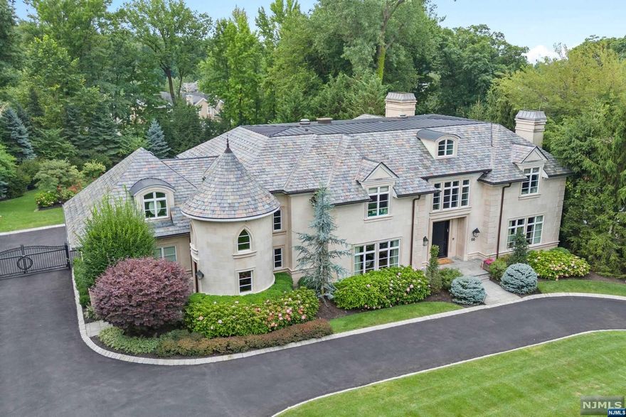 European-inspired estate w/limestone construction & slate roof located on Tenafly's prestigious East Hill. Showcasing exquisite architectural details, including X-pattern oak & radiant heated stone floors. A soaring 40-foot entry foyer features a hand-forged railing on the sweeping staircase. Antique French gas fplcs add elegance while the smart full house Crestron system adds ease. The chef's kitchen has an expansive eat-in area with towering 20-foot ceiling & walls of glass offering breathtaking views of the grounds. Equipped w/SubZero & Wolf appliances plus 2 refrigerators. The primary suite offers a spa-like bath & Juliet balcony w/sunset views boasting a 20-foot ceiling. Entertain w/a state-of-the-art movie theater & well-appointed wine cellar. The backyard is a resort-like oasis; a 20x40 saltwater pool & large spa both w/electric covers & full outdoor kit. Beautiful landscaping with extensive exterior lighting delivers privacy & elegance.